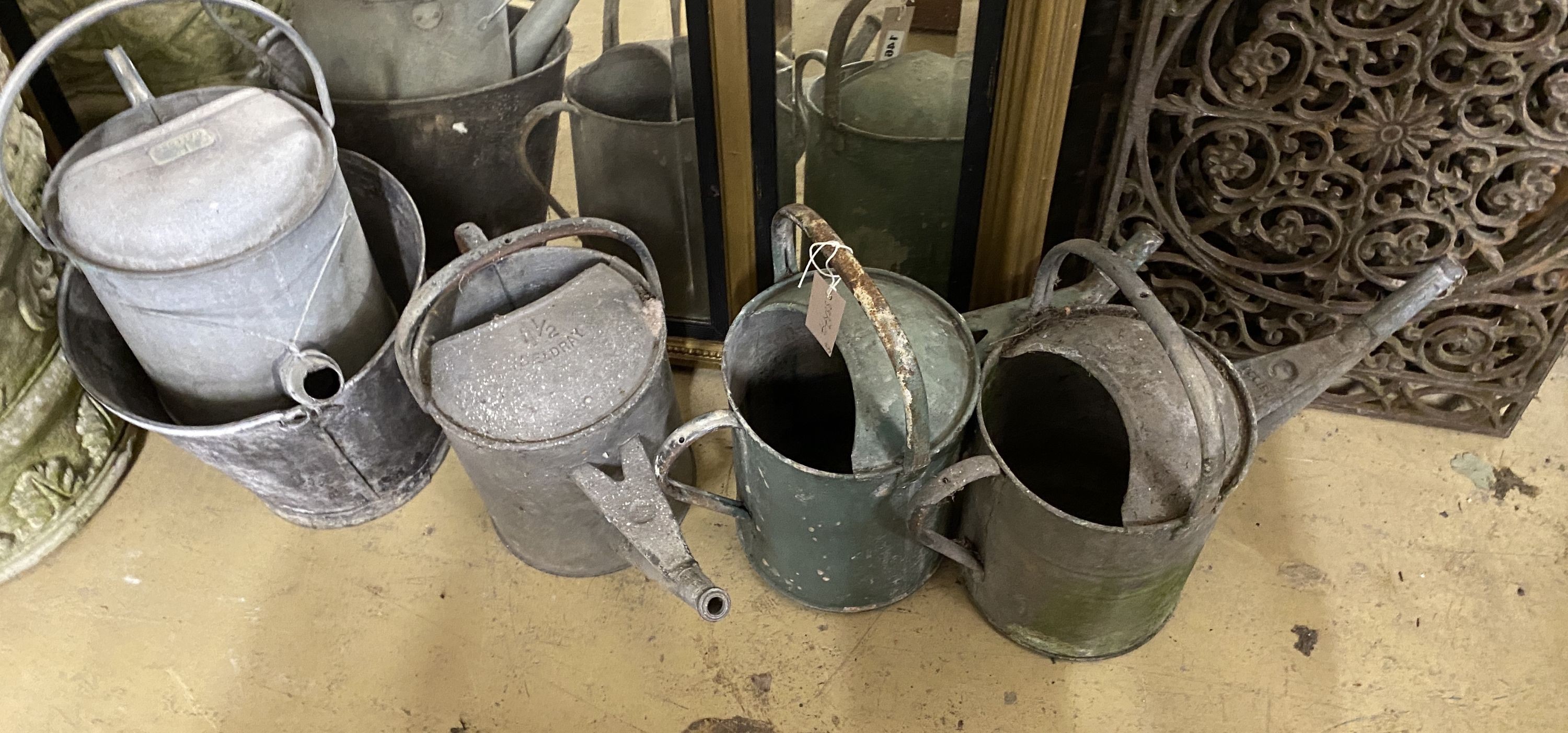 Four galvanised watering cans and a bucket